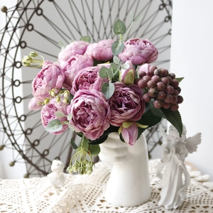 Detail of purple artificial peony and rose bouquet in a white aesthetic vase