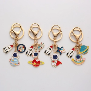 Detailed set of metal astronaut keychains featuring planets, stars, and colorful enamel rockets