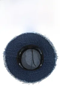 Close-up of the dark blue denim bucket hat interior with frayed edges and adjustable strap