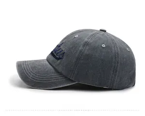 Detailed side view of washed gray baseball cap featuring navy blue letter embroidery