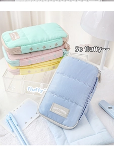 Detailed close-up of colorful quilted storage pouches with a fluffy texture and metal zipper