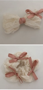 Detail of cream chiffon hair clip and scrunchie with pink ribbon ballet style bows