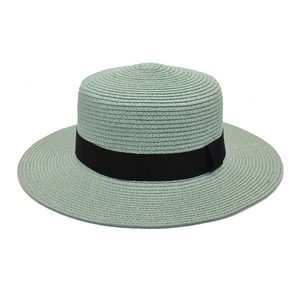 Close-up of the woven texture and black ribbon on the mint green boater straw hat