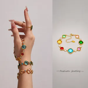 Dettaglio di un bracciale placcato oro 18k con gemme colorate e chiusura a moschettone regolabile