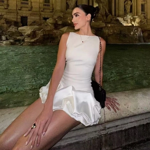 Robe courte blanche sans manches avec ourlet volanté devant un décor romain classique