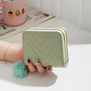 Short mint green quilted wallet for women featuring a double zipper and pom-pom decor