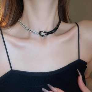 Dettaglio ravvicinato della collana bicolore nera e argento con perle e strass