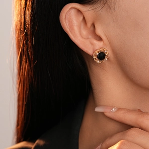 Gros plan sur les boucles d'oreilles vintage en or avec pierre noire et perles fines