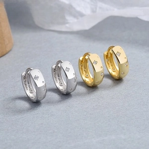 Detail view of S925 sterling silver hoop earrings with starburst pattern and zircon stones