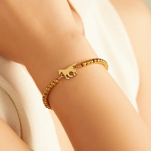 Detail of 18K gold-plated bead bracelet with a flat horse-shaped pendant on wrist