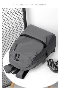 Detailed top view of dark grey waterproof backpack with dual front zip pockets and headset