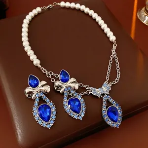 Vintage silver bow necklace and teardrop sapphire earrings set on leather