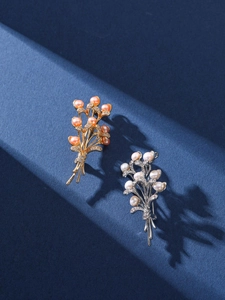 Detail of vintage wheat ear brooches with freshwater pearls in gold and silver finishes
