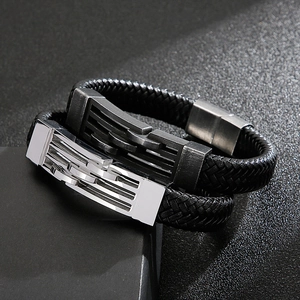 Détail d'un bracelet en cuir tressé avec fermoir magnétique en acier sur fond de pierre