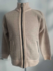 Detail of beige fleece-lined knit cardigan featuring waffle texture and black zipper accent