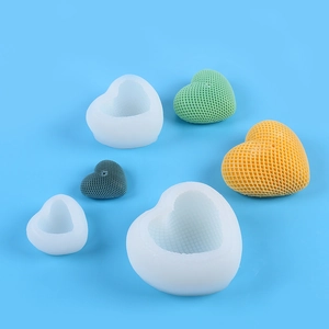 Detailed view of heart-shaped silicone molds and finished candles with grid texture