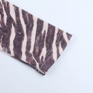 Détail macro du tissu en maille zébrée montrant la couture double de haute qualité