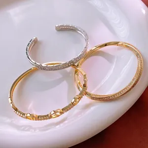 Three gold and silver plated CZ encrusted pig nose bangle set on a white ceramic plate