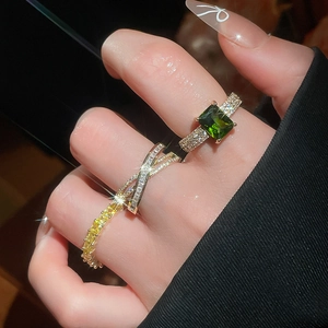 Macro shot of 18k gold plated ring set with emerald cut green stone and pave zircons