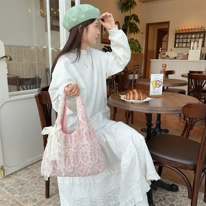Detail of pink vintage lace shoulder bag with intricate embroidery on the canvas body