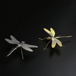 Detailed macro view of dragonfly lid rest in polished gold and silver metal finishes
