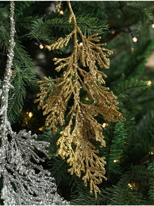 Close-up of golden and silver sequin cypress leaf ornaments hanging on a Christmas tree