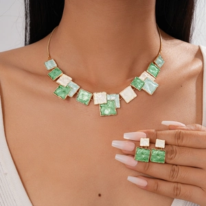 Detailed view of emerald green enamel geometric square necklace and earring set