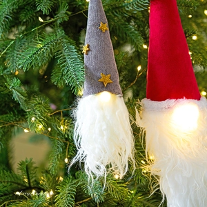 Light-up Christmas gnome hanging ornaments with white beards on a decorated Xmas tree