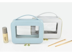 Detail of travel makeup bags in light blue and grey with clear PVC windows and gold zippers