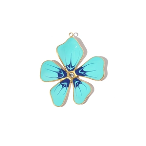 Detail of flower-shaped pendant with blue enamel, gold edges and a center sparkling crystal