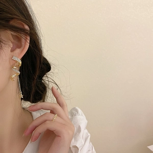Boucles d'oreilles spirales dorées avec étoiles en strass sur un mannequin féminin