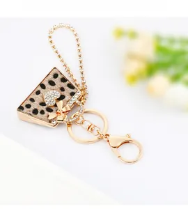 Detail of leopard print mini bag keychain with heart crystal and gold metal hardware