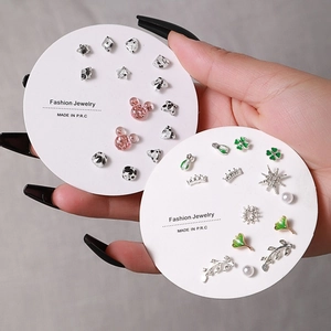 Detail of 30-pair earring set featuring pearls and motifs on round white display cards