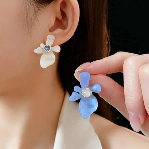Élégantes boucles d'oreilles fleur en résine avec zircone portées pour un style luxe