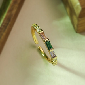 Detail of gold open ring with colorful rectangular gemstones and white zircon accents