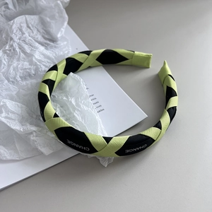 Detail of green and black checkered headband with CHANGE text on soft wrinkled paper