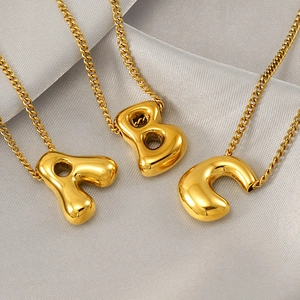Golden bubble letter A B C pendant necklaces on silk background for women