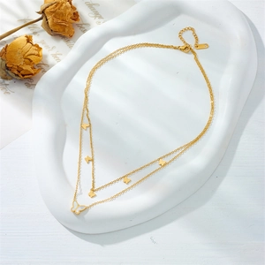 Close-up of double-layer gold necklace with butterfly charms and white mother-of-pearl inlay