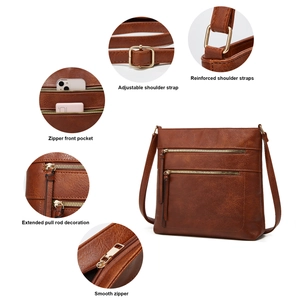 Detail view of adjustable strap hooks and reinforced metal zippers on dark brown tote bag