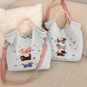 Detail of light blue quilted tote with cute cat and dog embroidery and pink straps