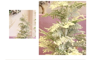 Detail of flocked Christmas cedar branch with white berries for window display decor