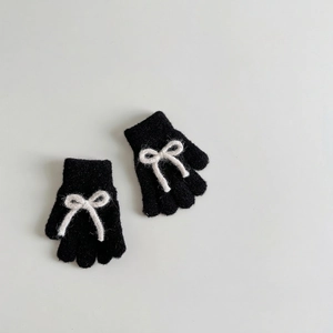 Close-up of black knit gloves with white bow details and soft plush warm material