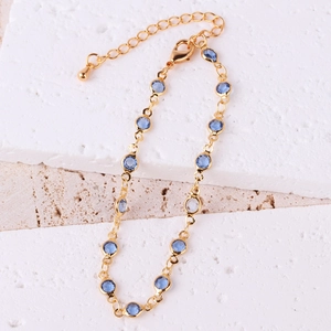 Detail of gold plated bracelet with faceted blue zircons and adjustable lobster clasp