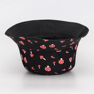 Close-up of black bucket hat featuring red mushroom print and fine stitching details