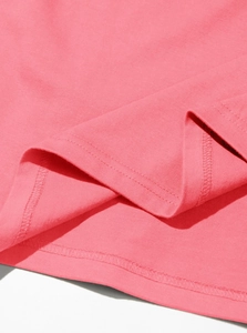 Detail of double-needle stitching on the hem of a pink cotton short sleeve T-shirt