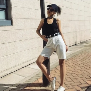 Detail of white denim shorts with casual black belt and side profile on outdoor model