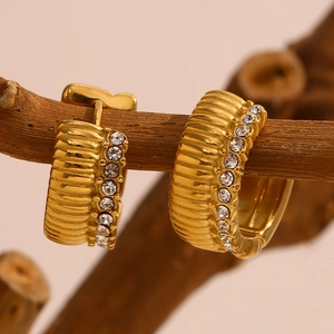 Macro shot of 18K gold plated hoop earrings with vertical texture and pavé zircon accents