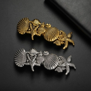 French vintage sea star shell hair clips in gold and silver finish on black background