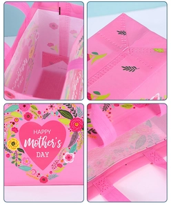 Detail view of pink Mother's Day gift bag showing handle stitching and floral patterns