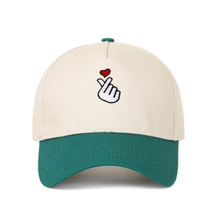 Detail of finger heart embroidery on two-tone off-white and green cotton baseball cap